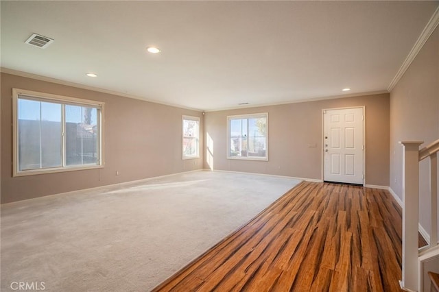 carpeted spare room featuring crown molding and plenty of natural light