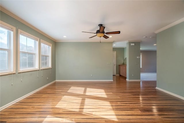 spare room featuring light hardwood / wood-style flooring, ceiling fan, and ornamental molding