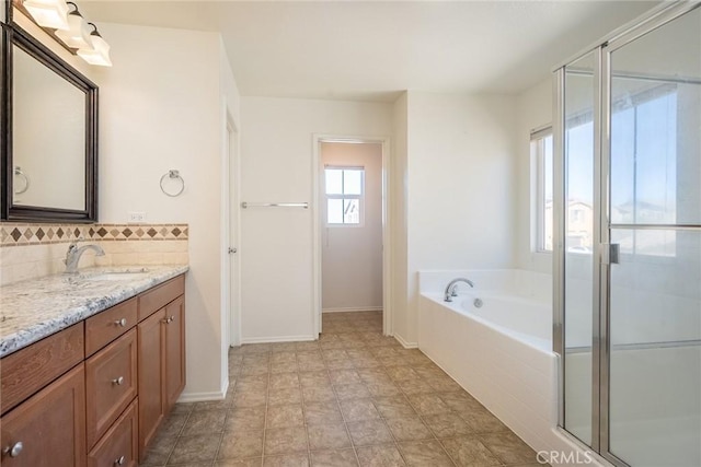 bathroom featuring tasteful backsplash, vanity, and independent shower and bath