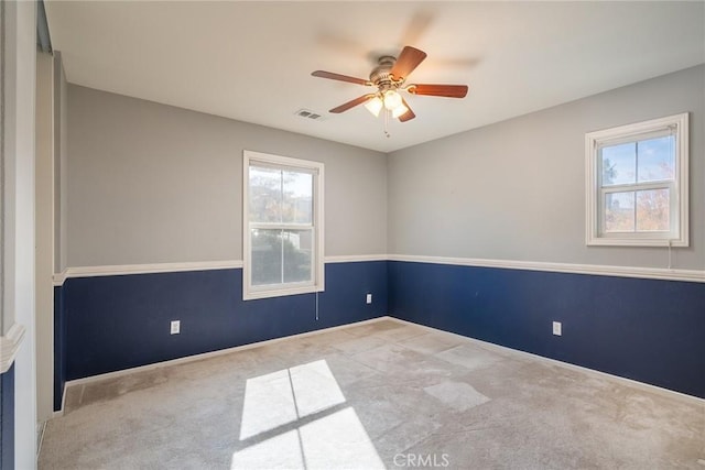 carpeted empty room featuring plenty of natural light and ceiling fan