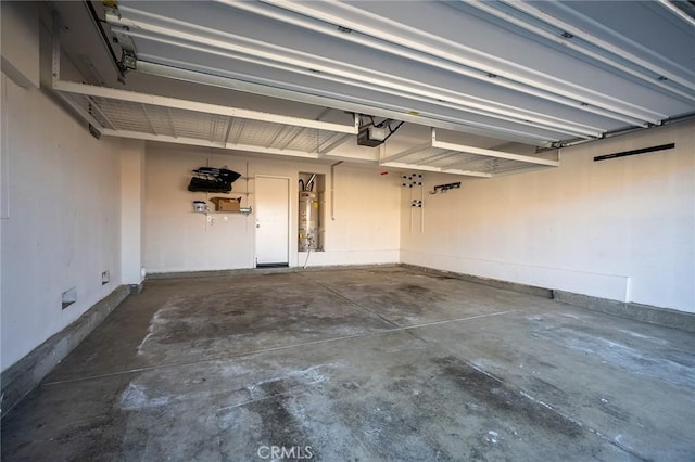 garage with strapped water heater and a garage door opener