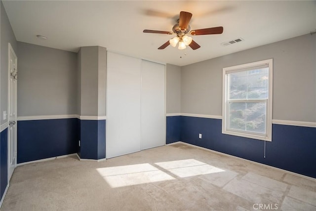 carpeted empty room featuring ceiling fan