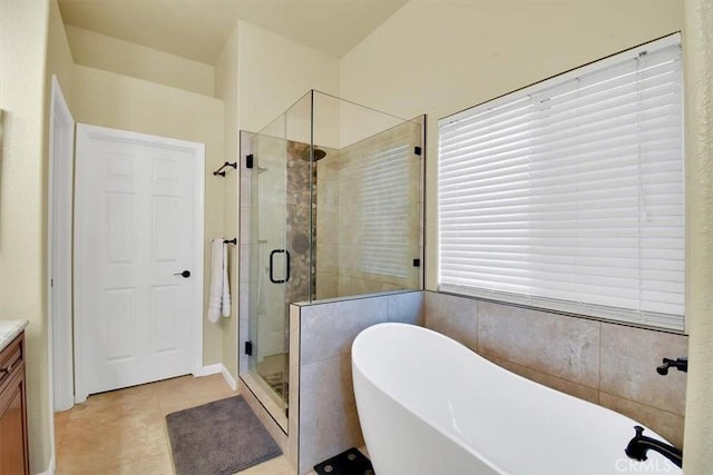 bathroom featuring tile patterned flooring, vanity, and plus walk in shower