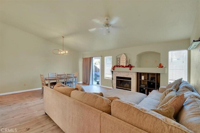 living room featuring light hardwood / wood-style flooring and ceiling fan with notable chandelier