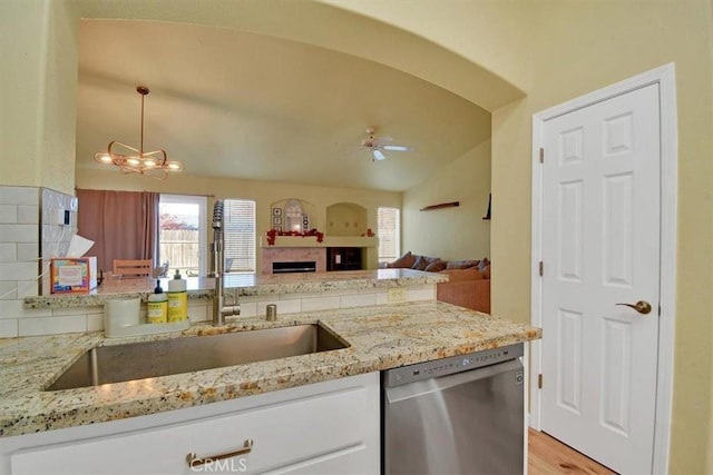 kitchen featuring decorative backsplash, sink, decorative light fixtures, dishwasher, and lofted ceiling