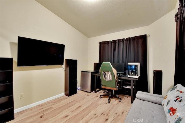 office space with light hardwood / wood-style floors and vaulted ceiling