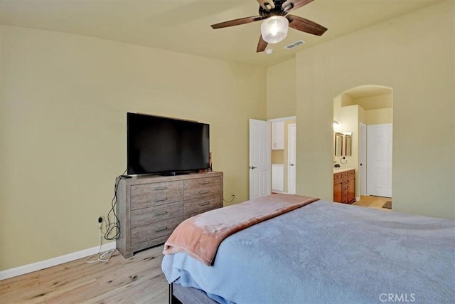 bedroom featuring ensuite bathroom, ceiling fan, and light wood-type flooring