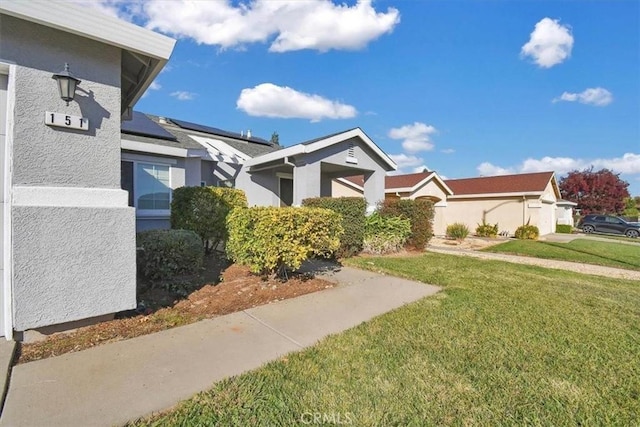 view of front of home with a front yard and solar panels