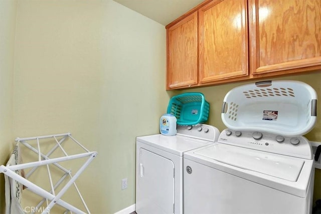 clothes washing area with cabinets and independent washer and dryer