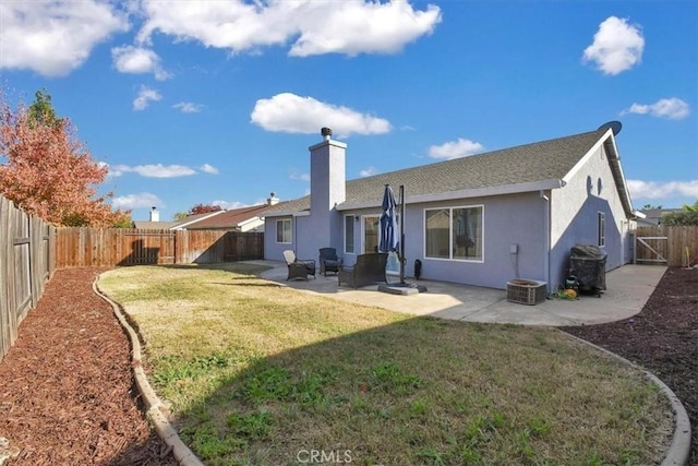 back of property with a yard and a patio