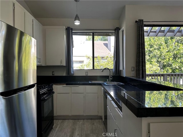 kitchen with pendant lighting, dark wood-type flooring, black appliances, sink, and white cabinetry