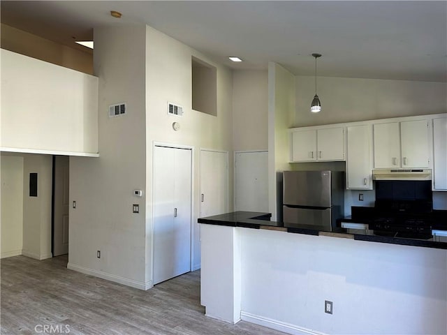 kitchen featuring black gas range, high vaulted ceiling, white cabinetry, and stainless steel refrigerator