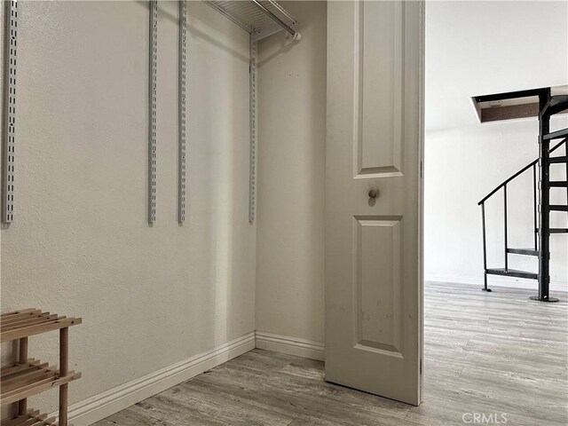 walk in closet with light wood-type flooring