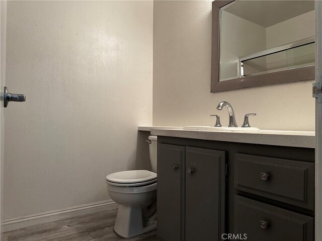 bathroom featuring hardwood / wood-style flooring, vanity, and toilet