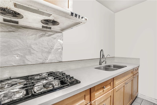 kitchen featuring ventilation hood, black gas stovetop, and sink