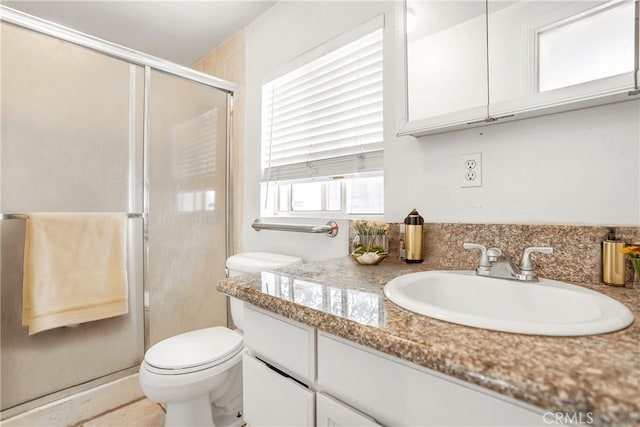 bathroom featuring vanity, toilet, and an enclosed shower