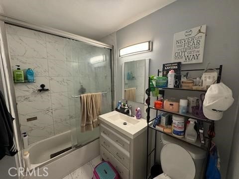 full bathroom featuring vanity, bath / shower combo with glass door, and toilet