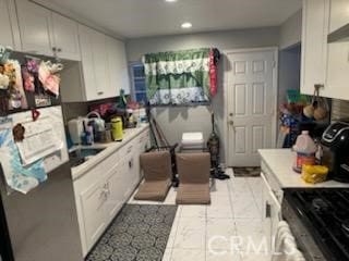 kitchen featuring white cabinetry and stainless steel fridge