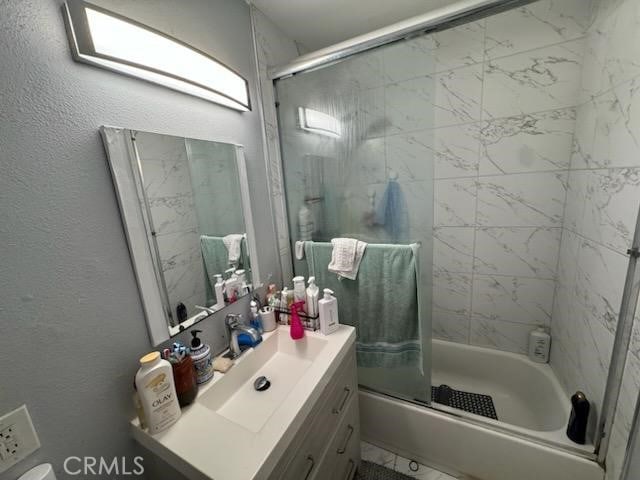 bathroom with combined bath / shower with glass door and vanity