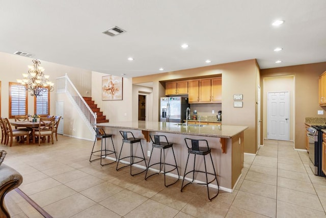 kitchen featuring a breakfast bar area, a large island, light tile patterned floors, and stainless steel appliances