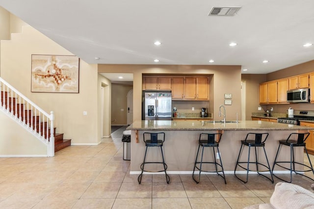 kitchen with a breakfast bar, a spacious island, sink, and appliances with stainless steel finishes