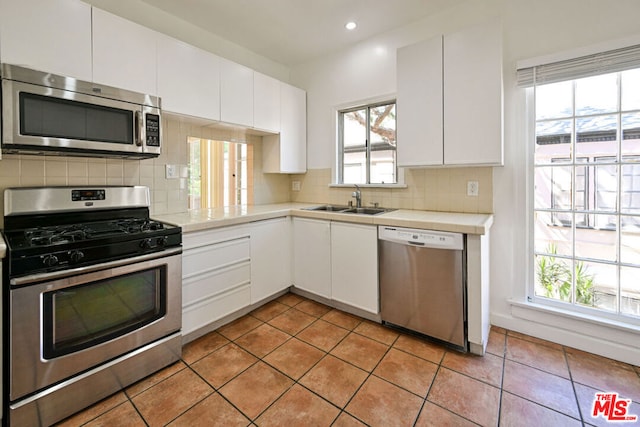 kitchen featuring a healthy amount of sunlight, sink, white cabinets, and stainless steel appliances