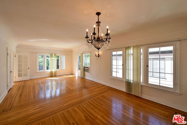 interior space featuring cooling unit, wood-type flooring, and an inviting chandelier