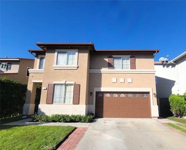 view of front of home with a garage, concrete driveway, and stucco siding