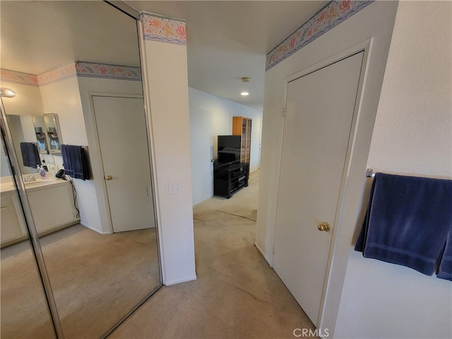 hall featuring light colored carpet and washer / clothes dryer