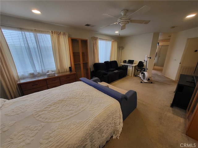 carpeted bedroom with ceiling fan and multiple windows