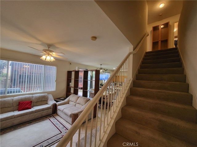 stairway featuring plenty of natural light, a ceiling fan, and tile patterned floors