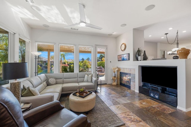 living room featuring ceiling fan and a fireplace