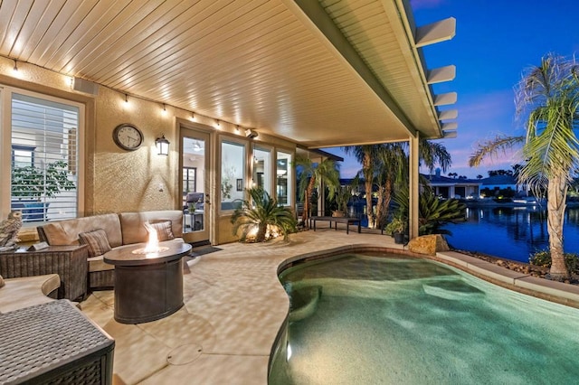 pool at dusk featuring a fire pit and a patio