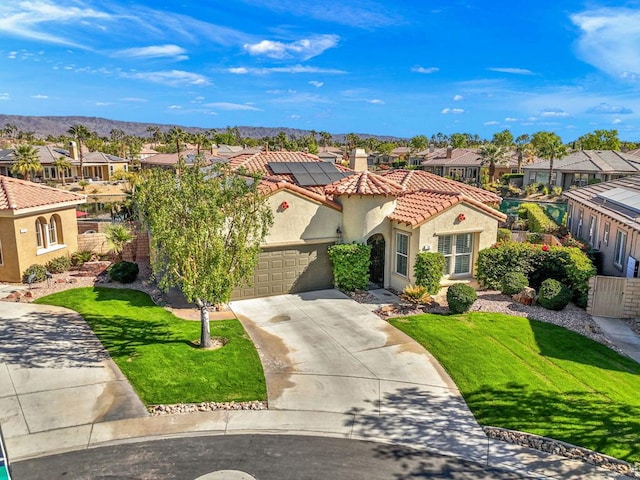 mediterranean / spanish-style home featuring a front yard and solar panels