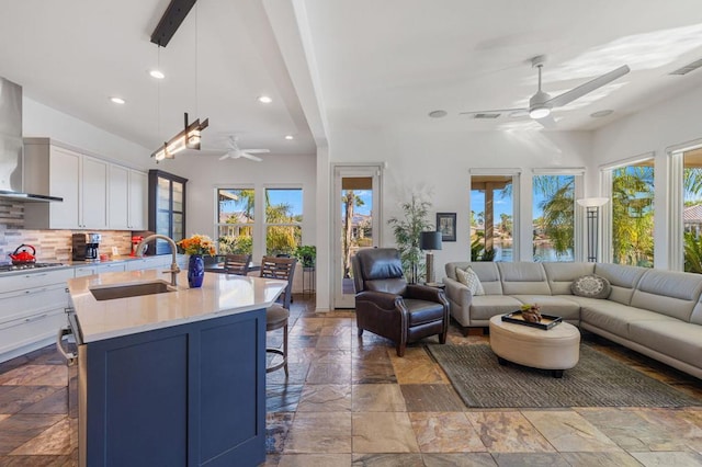 interior space with ceiling fan, beam ceiling, and sink