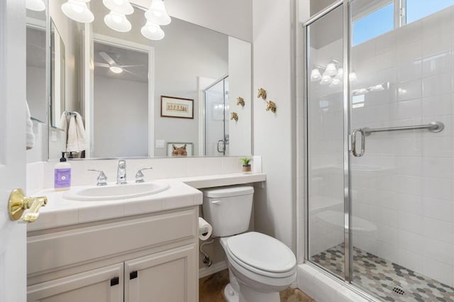 bathroom featuring vanity, a shower with shower door, and toilet