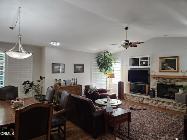 living room featuring dark hardwood / wood-style floors, ceiling fan, a fireplace, and vaulted ceiling