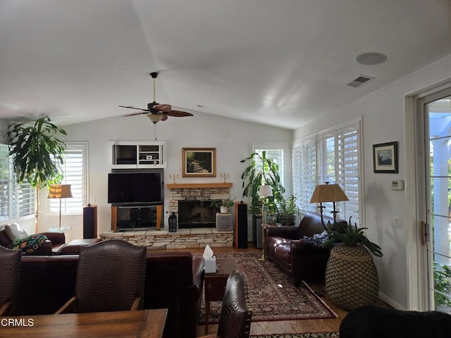 living room with a fireplace, ceiling fan, plenty of natural light, and vaulted ceiling