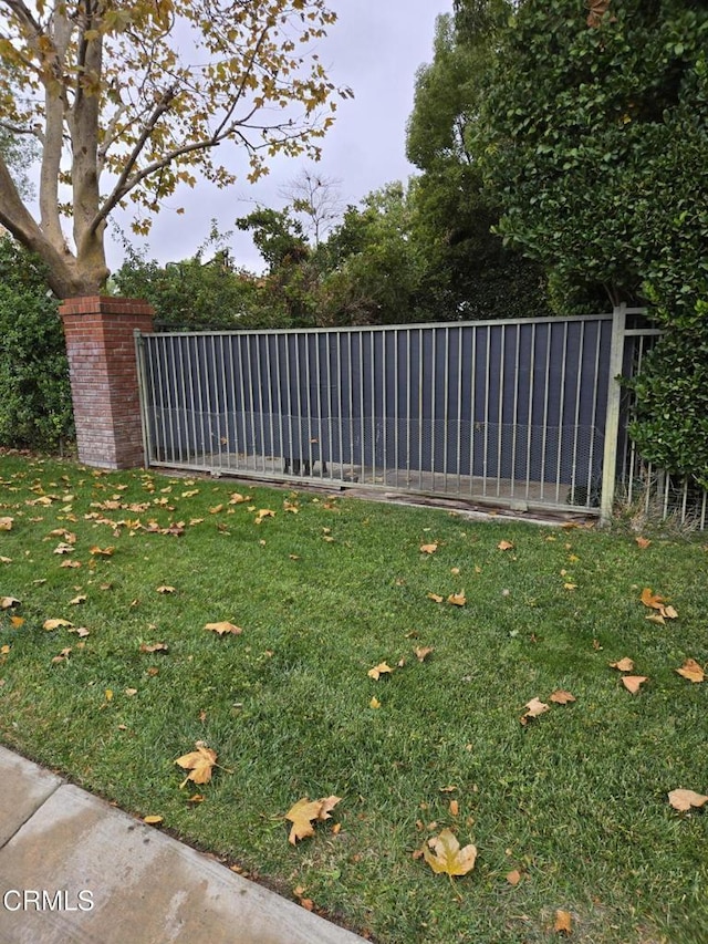 view of gate with a lawn