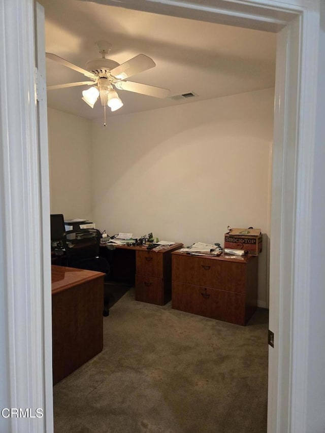 carpeted office space with ceiling fan