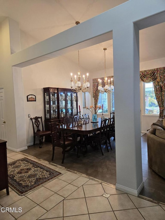 dining room featuring tile patterned flooring, lofted ceiling, and a notable chandelier