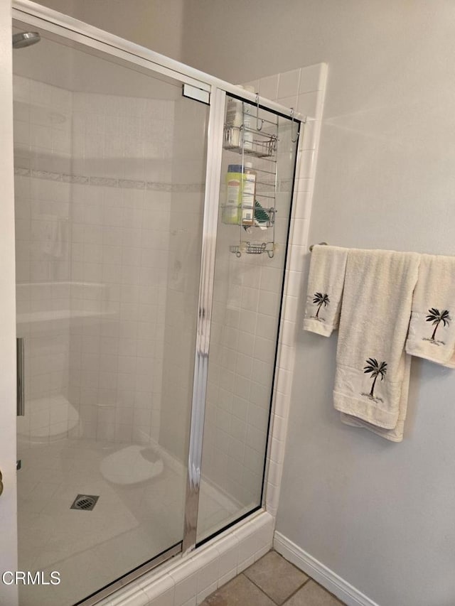 bathroom featuring tile patterned floors and a shower with shower door