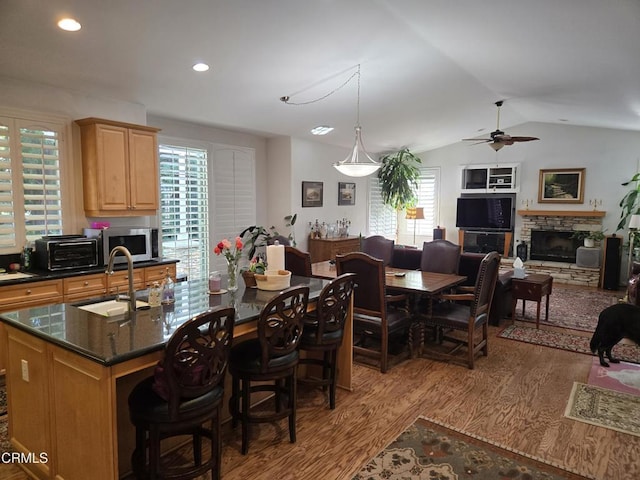 kitchen with hardwood / wood-style flooring, vaulted ceiling, a healthy amount of sunlight, and sink