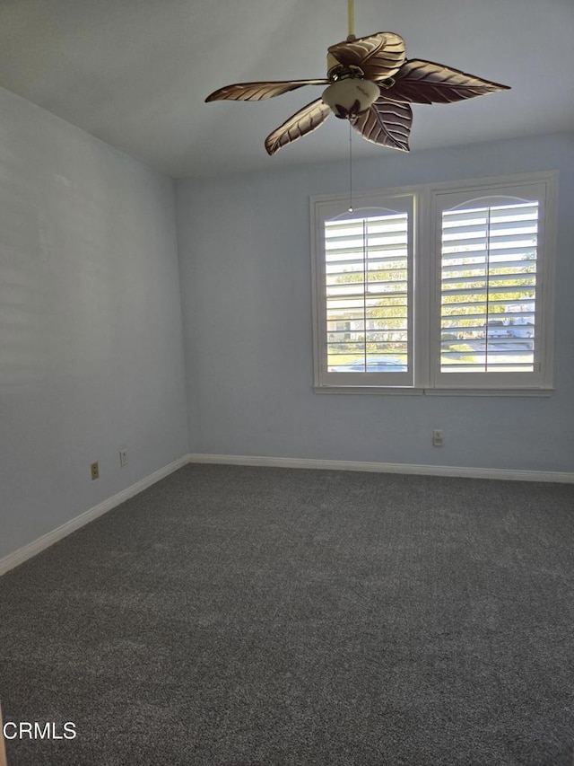 spare room with ceiling fan and dark carpet