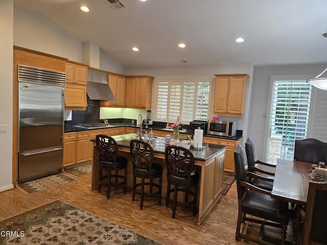 kitchen featuring a wealth of natural light, a center island with sink, lofted ceiling, and appliances with stainless steel finishes