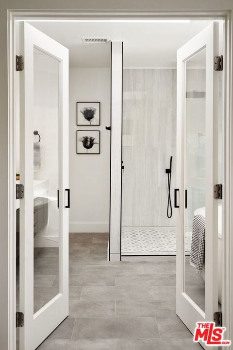 bathroom with a tile shower and french doors