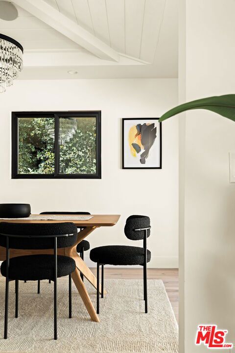 office area featuring vaulted ceiling with beams, a notable chandelier, and light wood-type flooring