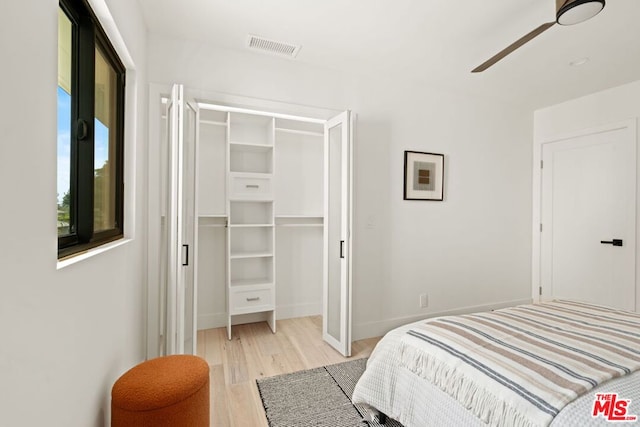 bedroom with ceiling fan, light wood-type flooring, and a closet