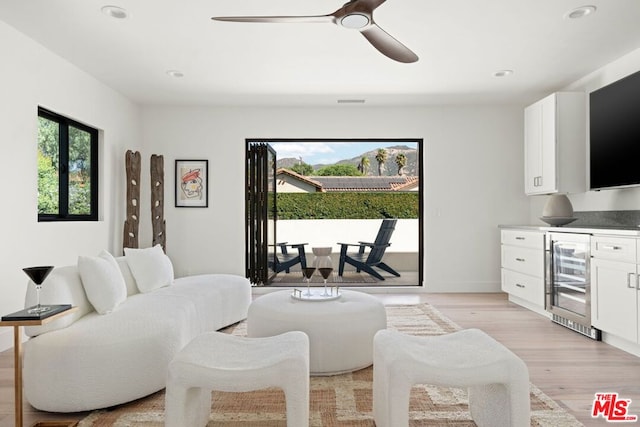 interior space with light hardwood / wood-style flooring, beverage cooler, and ceiling fan