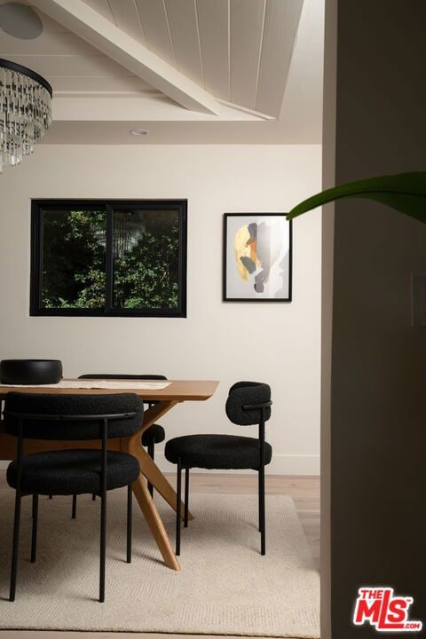 interior space with beamed ceiling, a chandelier, and wood-type flooring